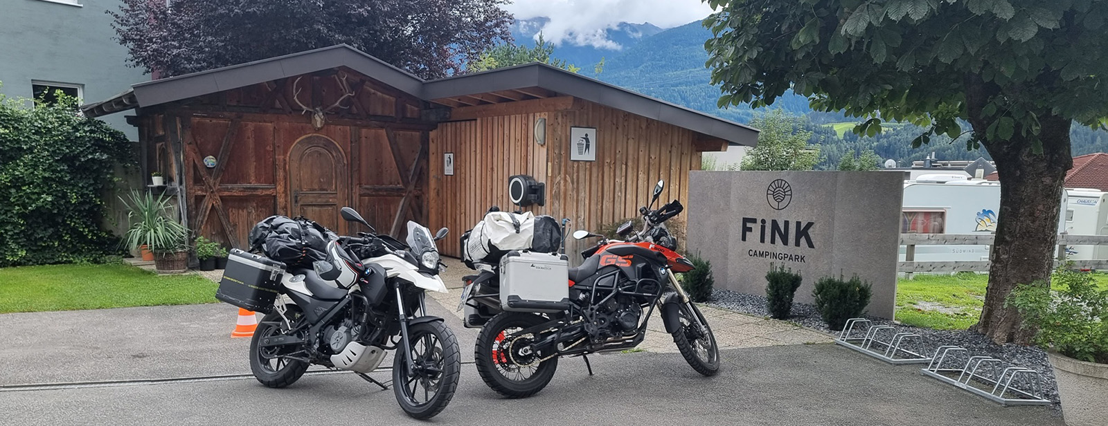 Zwei Motorräder vor dem Schild eines Campingplatzes